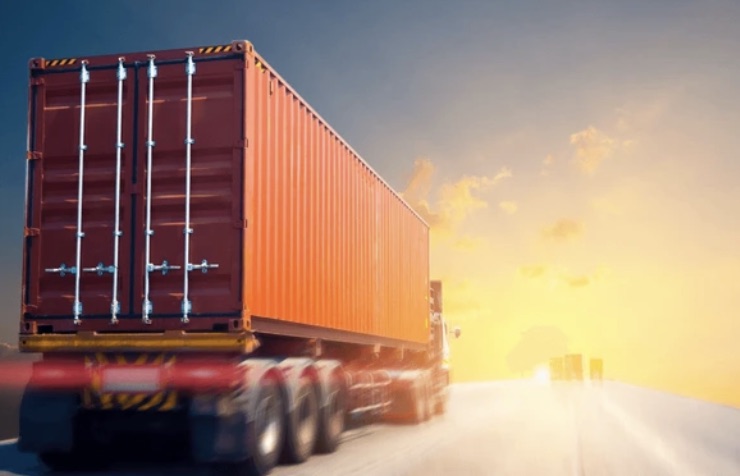 Truck hauling a shipping container on a highway at sunset — cross-border B2B trade between Mexico and the U.S.