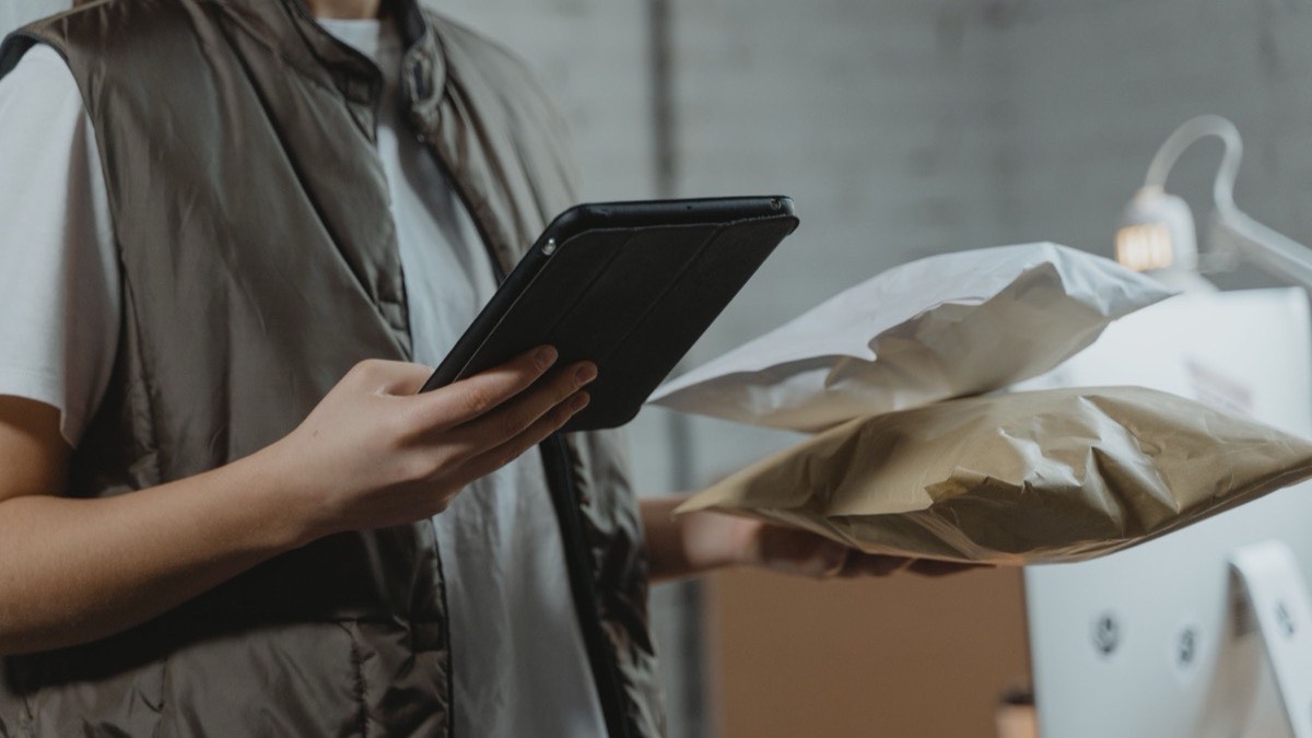 Operadora de almacén con tablet revisa un pedido empaquetado — integración PunchOut y procurement digital en eCommerce B2B