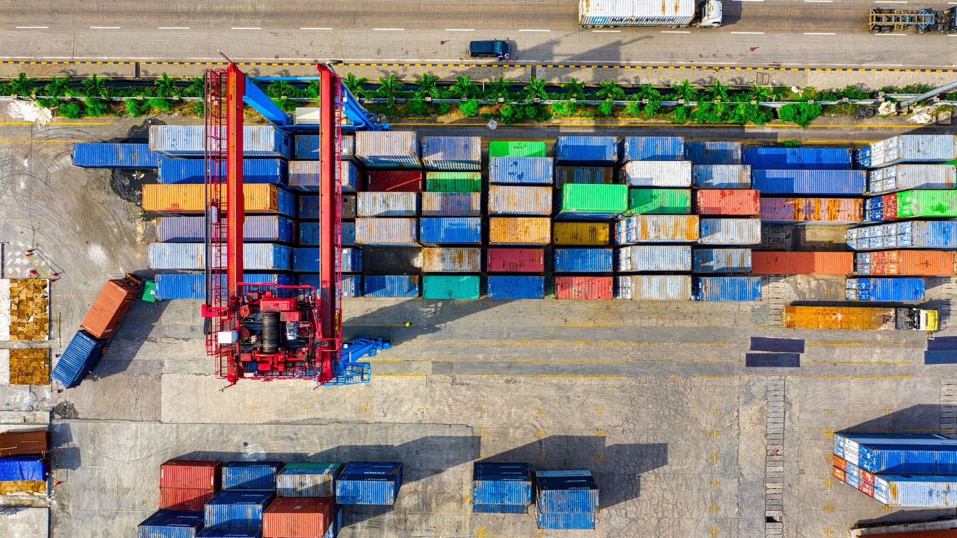 Vista aérea de una terminal portuaria de contenedores con grúa pórtico y camiones, logística y comercio B2B multiindustria en México