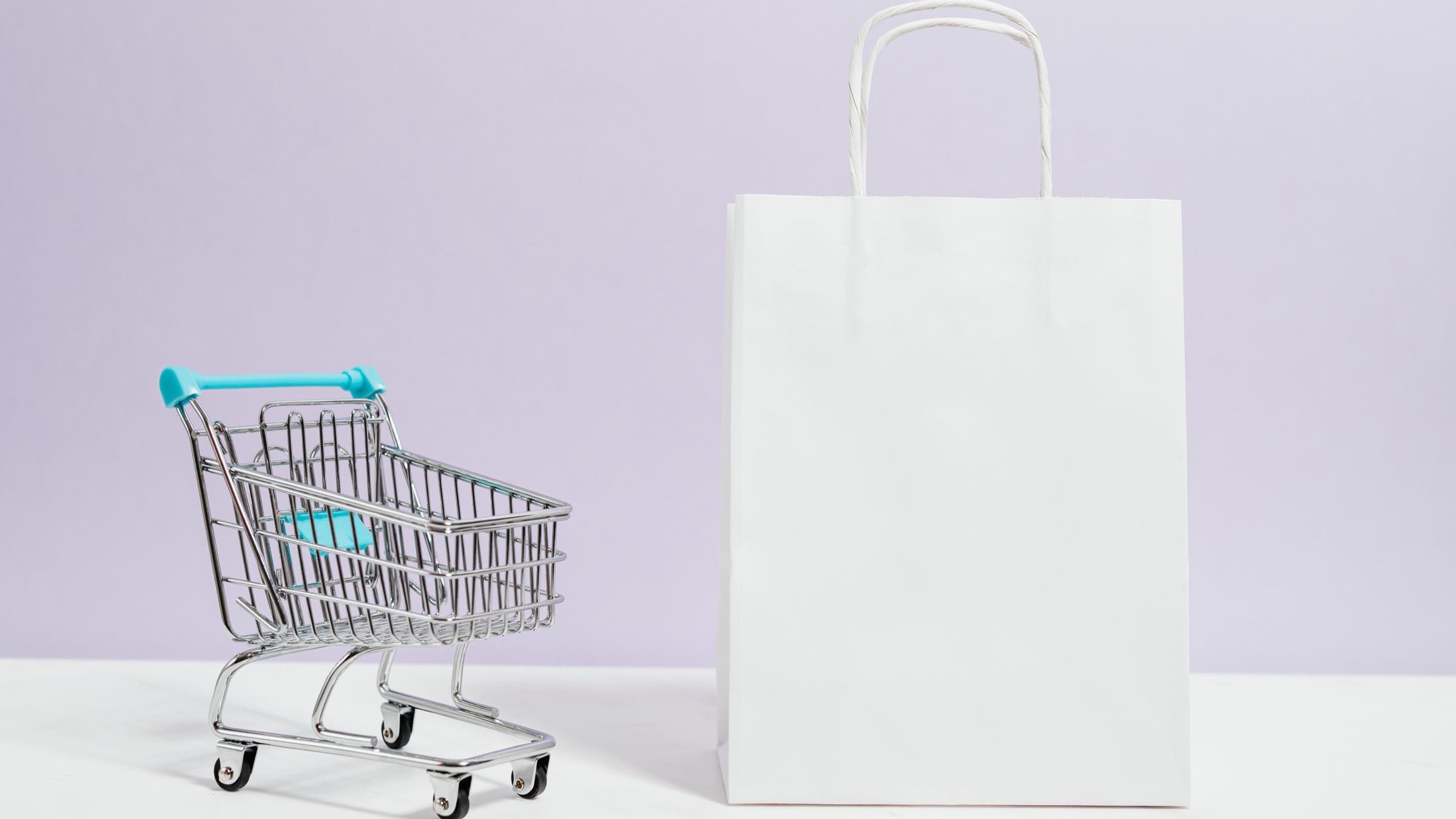 Miniature shopping cart and white store bag on a lilac background — AI-powered retail B2C ecommerce in Mexico